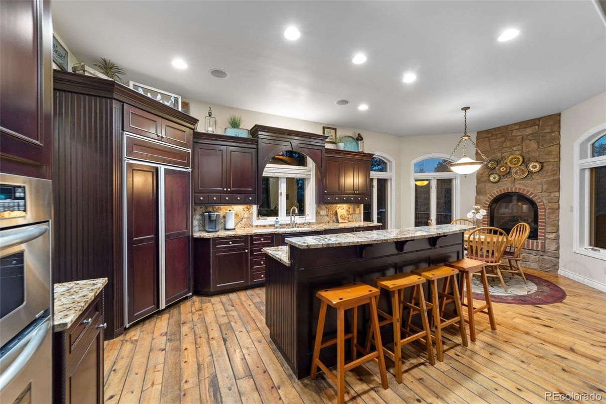 Fireplace, Interior, Kitchen, Pendant Lights, Recessed Lighting, Stainless Steel Appliances, Stone Walls, Wood Texture Flooring