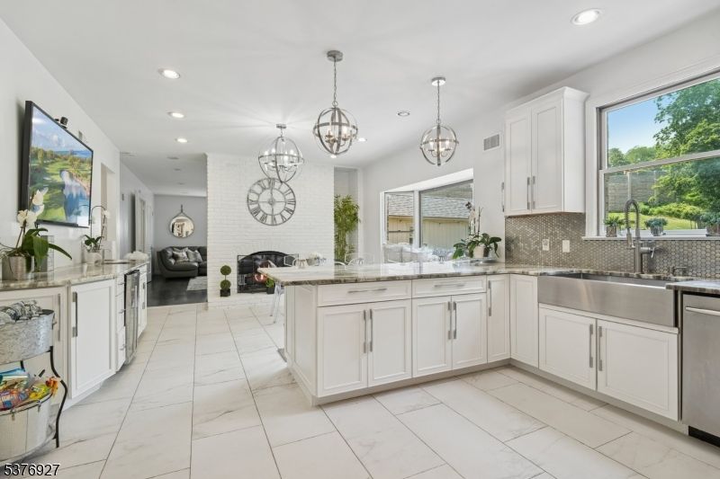 Chandelier, Fireplace, Interior, Kitchen, Living room, Marble, Pendant Lights, Recessed Lighting, Stainless Steel Appliances, Stone Walls