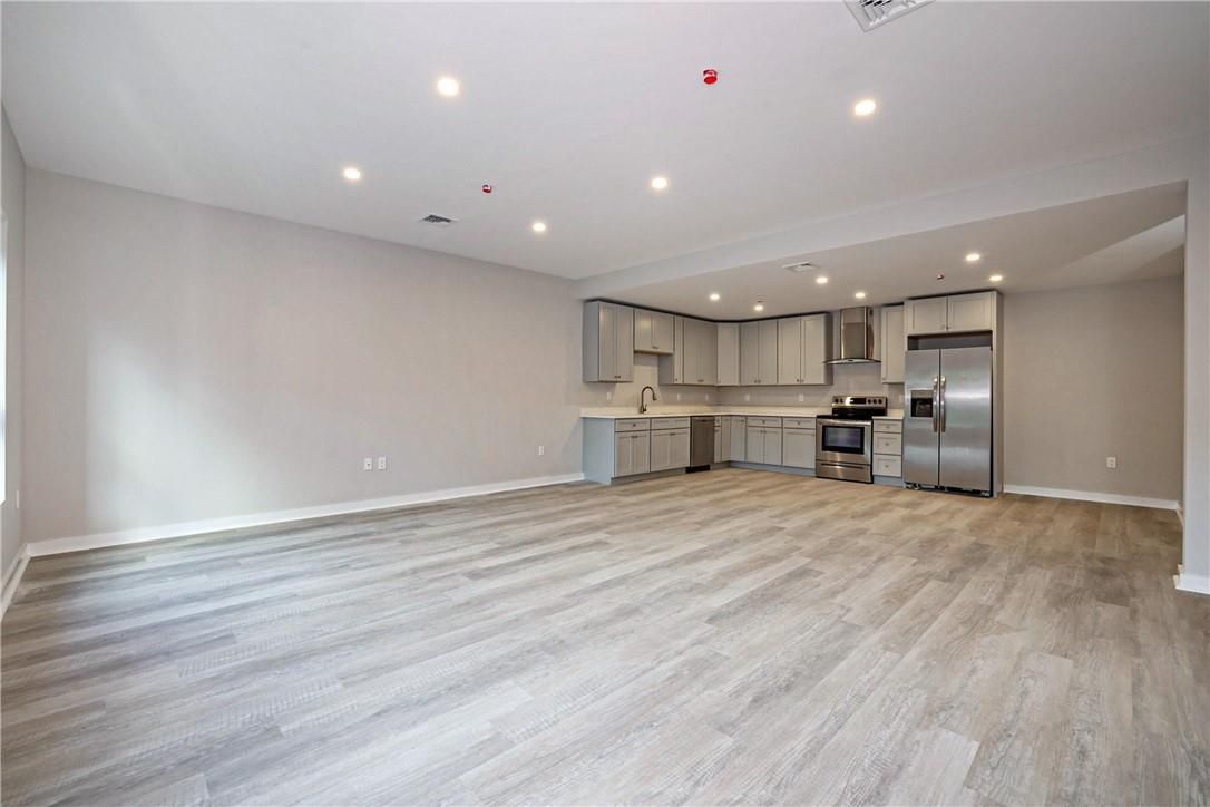 Empty room, Interior, Kitchen, Recessed Lighting, Stainless Steel Appliances, Wood Texture Flooring