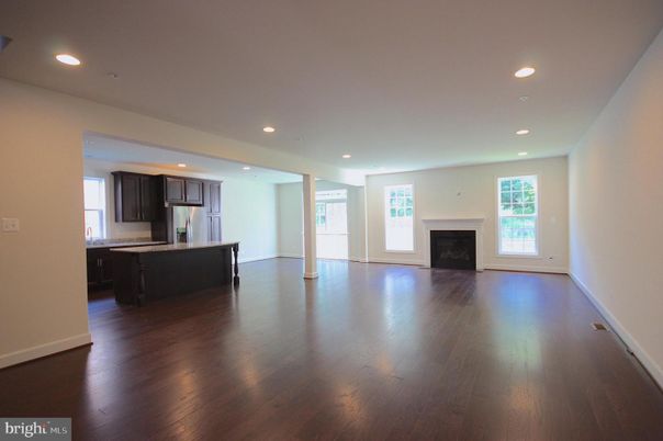 Empty room, Fireplace, Interior, Kitchen, Recessed Lighting, Stainless Steel Appliances, Wood Texture Flooring