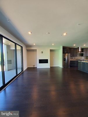 Empty room, Fireplace, Interior, Kitchen, Recessed Lighting, Stainless Steel Appliances, Wood Texture Flooring
