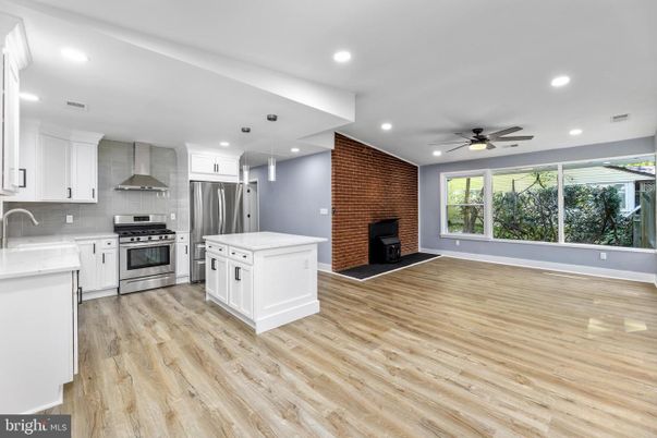 Empty room, Fireplace, Interior, Kitchen, Recessed Lighting, Stainless Steel Appliances, Stone Walls, Wood Texture Flooring