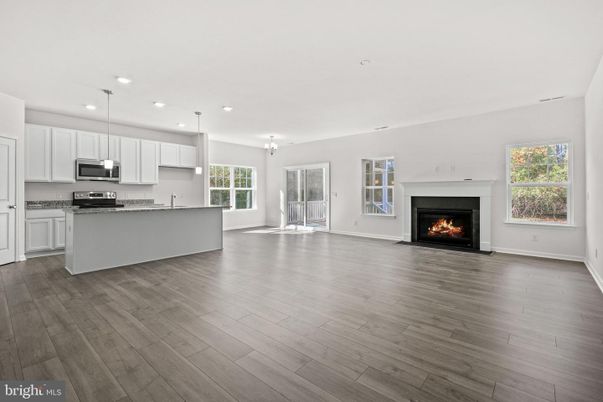 Empty room, Fireplace, Interior, Kitchen, Pendant Lights, Recessed Lighting, Stainless Steel Appliances, Wood Texture Flooring