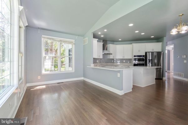 Empty room, Interior, Kitchen, Recessed Lighting, Stainless Steel Appliances, Wood Texture Flooring