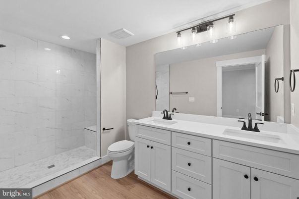 Bathroom, Dual Sink Vanities, Glass Shower, Interior, Marble Walls, Recessed Lighting, Wood Texture Flooring