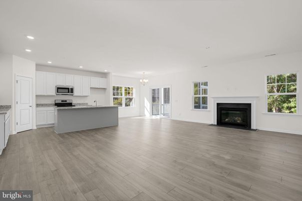 Chandelier, Empty room, Fireplace, Interior, Kitchen, Recessed Lighting, Stainless Steel Appliances, Wood Texture Flooring