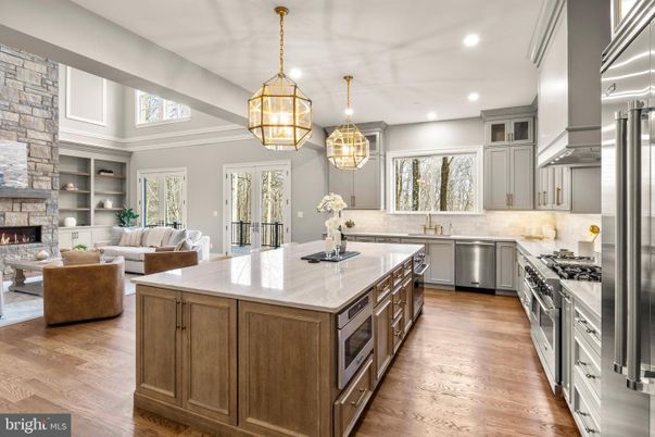 Fireplace, Interior, Kitchen, Living room, Pendant Lights, Recessed Lighting, Stainless Steel Appliances, Stone Walls, Wood Texture Flooring