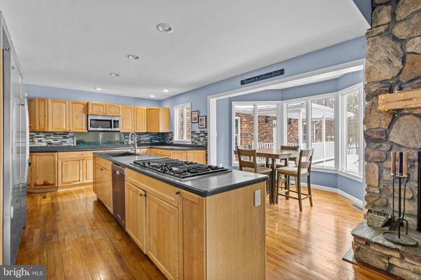 Dining room, Fireplace, Interior, Kitchen, Recessed Lighting, Stainless Steel Appliances, Stone Walls, Wood Texture Flooring