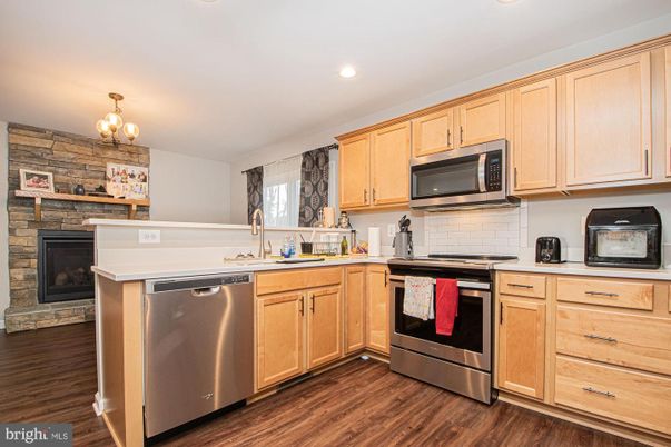 Fireplace, Interior, Kitchen, Recessed Lighting, Stainless Steel Appliances, Stone Walls, Wood Texture Flooring