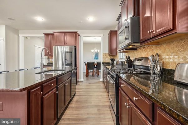 Chandelier, Dining room, Interior, Kitchen, Pendant Lights, Recessed Lighting, Stainless Steel Appliances, Wood Texture Flooring
