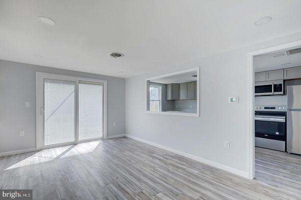 Empty room, Interior, Kitchen, Recessed Lighting, Stainless Steel Appliances, Wood Texture Flooring
