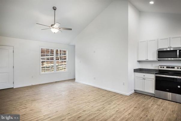 Empty room, Interior, Kitchen, Recessed Lighting, Stainless Steel Appliances, Wood Texture Flooring