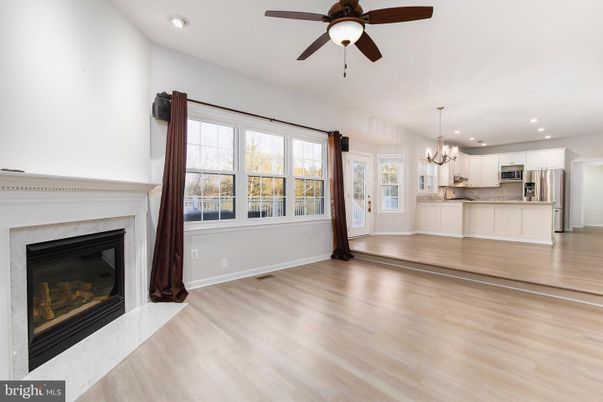 Chandelier, Empty room, Fireplace, Interior, Kitchen, Recessed Lighting, Stainless Steel Appliances, Wood Texture Flooring
