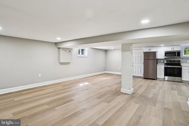 Empty room, Interior, Kitchen, Recessed Lighting, Stainless Steel Appliances, Wood Texture Flooring