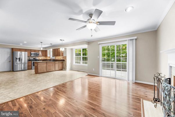 Empty room, Fireplace, Interior, Kitchen, Pendant Lights, Recessed Lighting, Stainless Steel Appliances, Wood Texture Flooring