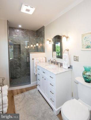 Bathroom, Dual Sink Vanities, Glass Shower, Interior, Marble Walls, Recessed Lighting, Wood Texture Flooring