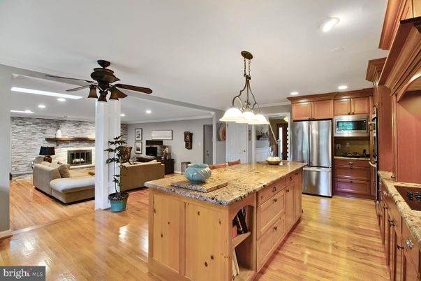 Fireplace, Interior, Kitchen, Living room, Pendant Lights, Recessed Lighting, Stainless Steel Appliances, Stone Walls, Wood Texture Flooring