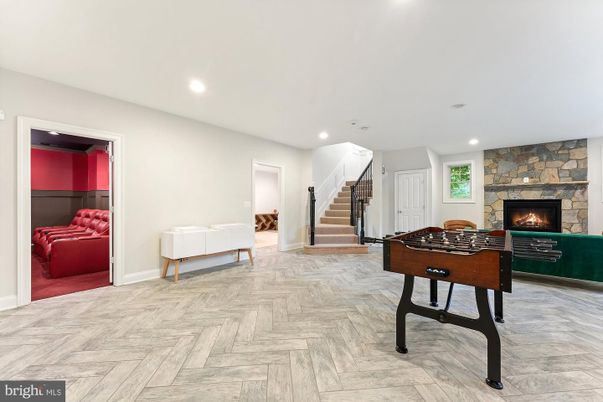 Fireplace, Game Room, Interior, Recessed Lighting, Stone Walls, Wood Texture Flooring