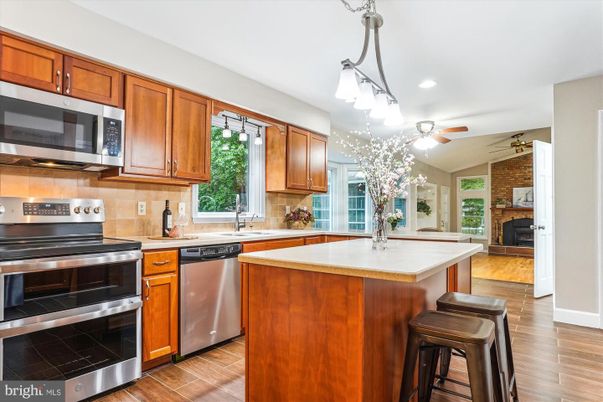 Fireplace, Interior, Kitchen, Pendant Lights, Recessed Lighting, Stainless Steel Appliances, Stone Walls, Wood Texture Flooring