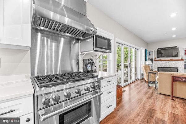 Dining room, Fireplace, Interior, Kitchen, Recessed Lighting, Stainless Steel Appliances, Wood Texture Flooring