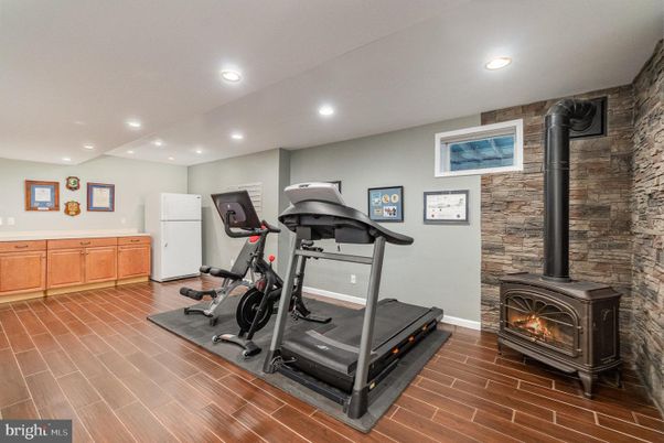 Fireplace, Fitness Equipment, Interior, Recessed Lighting, Stone Walls, Wood Texture Flooring