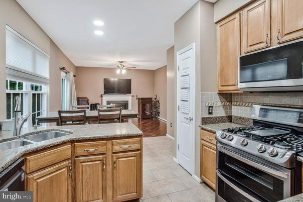 Dining room, Fireplace, Interior, Kitchen, Recessed Lighting, Stainless Steel Appliances, Wood Texture Flooring