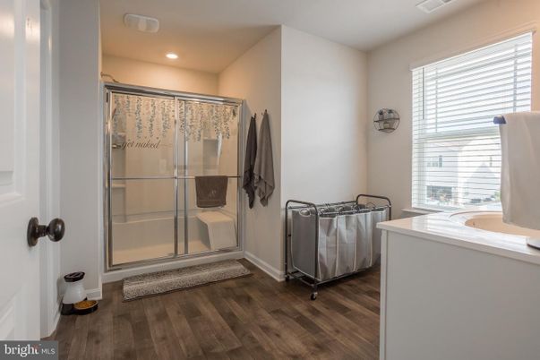 Bathroom, Glass Shower, Interior, Recessed Lighting, Washer, Wood Texture Flooring