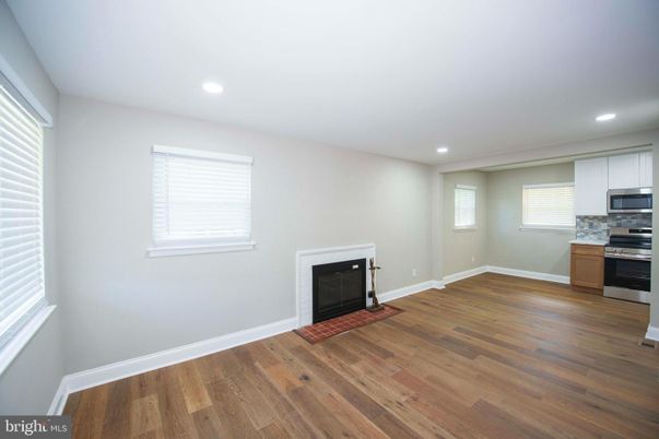 Empty room, Fireplace, Interior, Kitchen, Recessed Lighting, Stainless Steel Appliances, Wood Texture Flooring