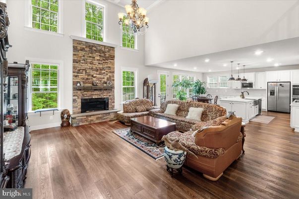 Chandelier, Fireplace, Interior, Kitchen, Living room, Pendant Lights, Recessed Lighting, Stainless Steel Appliances, Stone Walls, Wood Texture Flooring