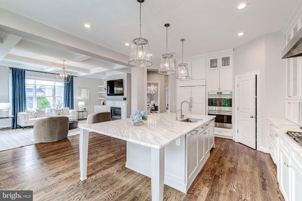 Chandelier, Fireplace, Interior, Kitchen, Living room, Pendant Lights, Recessed Lighting, Stainless Steel Appliances, Wood Texture Flooring