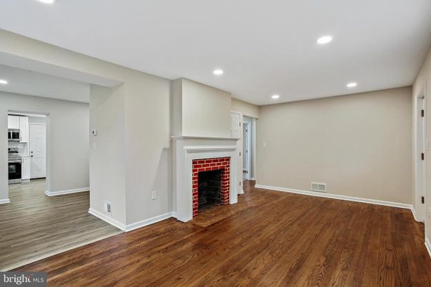 Empty room, Fireplace, Interior, Kitchen, Recessed Lighting, Stainless Steel Appliances, Wood Texture Flooring