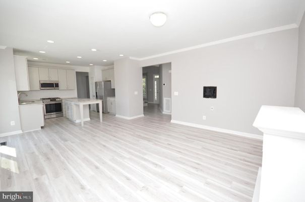 Empty room, Interior, Kitchen, Recessed Lighting, Stainless Steel Appliances, Wood Texture Flooring