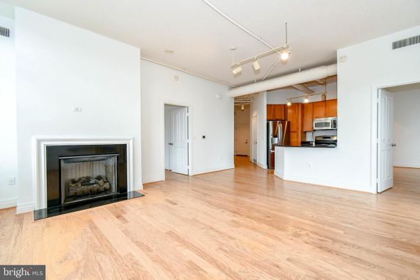Empty room, Fireplace, Interior, Kitchen, Pendant Lights, Stainless Steel Appliances, Wood Texture Flooring