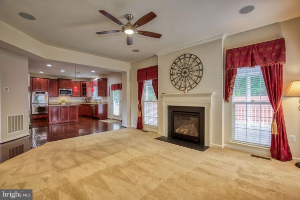 Empty room, Fireplace, Interior, Kitchen, Recessed Lighting, Stainless Steel Appliances, Wood Texture Flooring