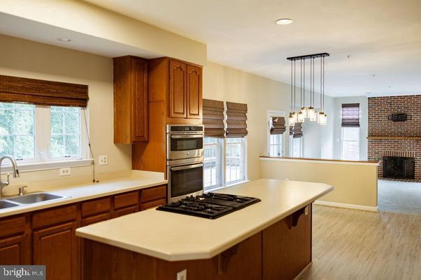 Fireplace, Interior, Kitchen, Pendant Lights, Recessed Lighting, Stainless Steel Appliances, Stone Walls, Wood Texture Flooring