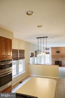 Fireplace, Interior, Kitchen, Pendant Lights, Recessed Lighting, Stainless Steel Appliances, Stone Walls, Wood Texture Flooring
