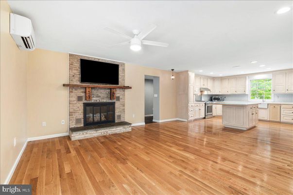 Empty room, Fireplace, Interior, Kitchen, Recessed Lighting, Stainless Steel Appliances, Stone Walls, Wood Texture Flooring