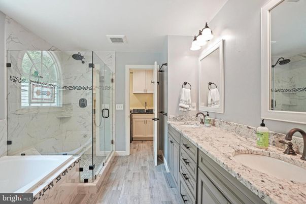 Bathroom, Dual Sink Vanities, Glass Shower, Interior, Marble Walls, Wood Texture Flooring