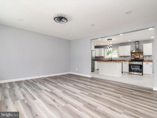 Empty room, Interior, Kitchen, Recessed Lighting, Stainless Steel Appliances, Wood Texture Flooring