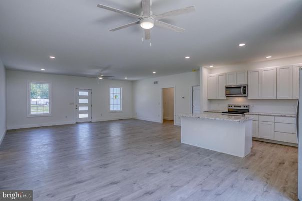 Empty room, Interior, Kitchen, Recessed Lighting, Stainless Steel Appliances, Wood Texture Flooring