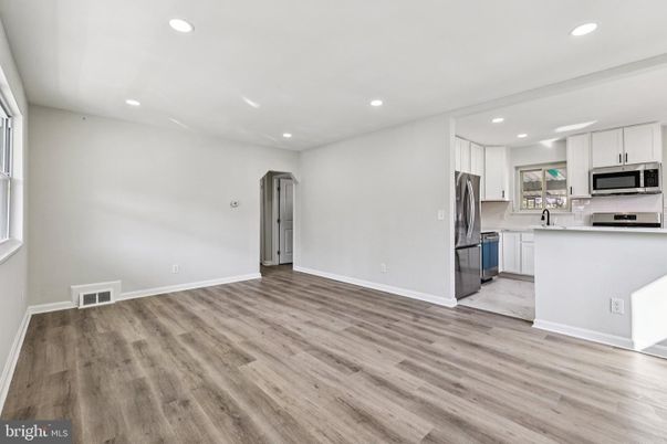 Empty room, Interior, Kitchen, Recessed Lighting, Stainless Steel Appliances, Wood Texture Flooring