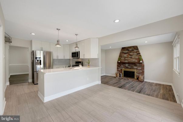 Fireplace, Interior, Kitchen, Pendant Lights, Recessed Lighting, Stainless Steel Appliances, Stone Walls, Wood Texture Flooring