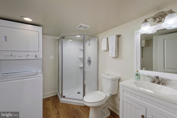 Bathroom, Glass Shower, Interior, Recessed Lighting, Washer, Wood Texture Flooring