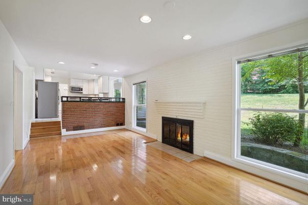 Empty room, Fireplace, Interior, Kitchen, Recessed Lighting, Stainless Steel Appliances, Wood Texture Flooring
