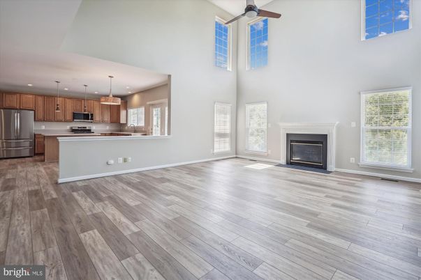 Empty room, Fireplace, Interior, Kitchen, Pendant Lights, Recessed Lighting, Stainless Steel Appliances, Wood Texture Flooring