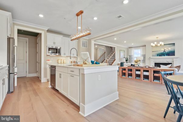 Chandelier, Fireplace, Interior, Kitchen, Living room, Pendant Lights, Recessed Lighting, Stainless Steel Appliances, Wood Texture Flooring