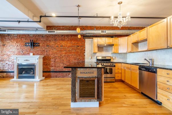 Chandelier, Fireplace, Interior, Kitchen, Pendant Lights, Recessed Lighting, Stainless Steel Appliances, Stone Walls, Wood Texture Flooring