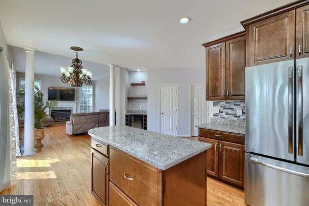 Chandelier, Fireplace, Interior, Kitchen, Living room, Recessed Lighting, Stainless Steel Appliances, Wood Texture Flooring