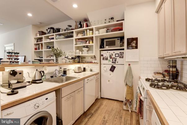 Interior, Kitchen, Recessed Lighting, Tile Countertops, Washer, Wood Texture Flooring
