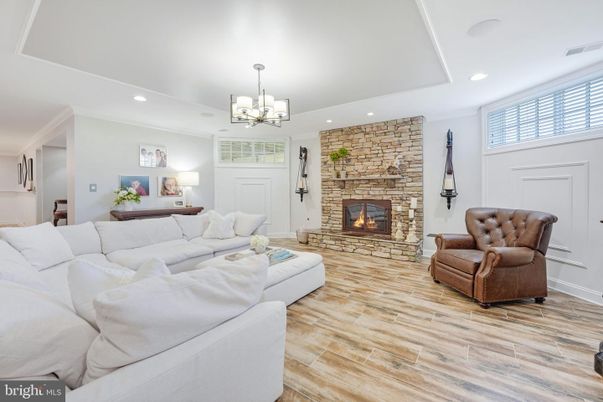 Chandelier, Fireplace, Interior, Living room, Recessed Lighting, Stone Walls, Wood Texture Flooring